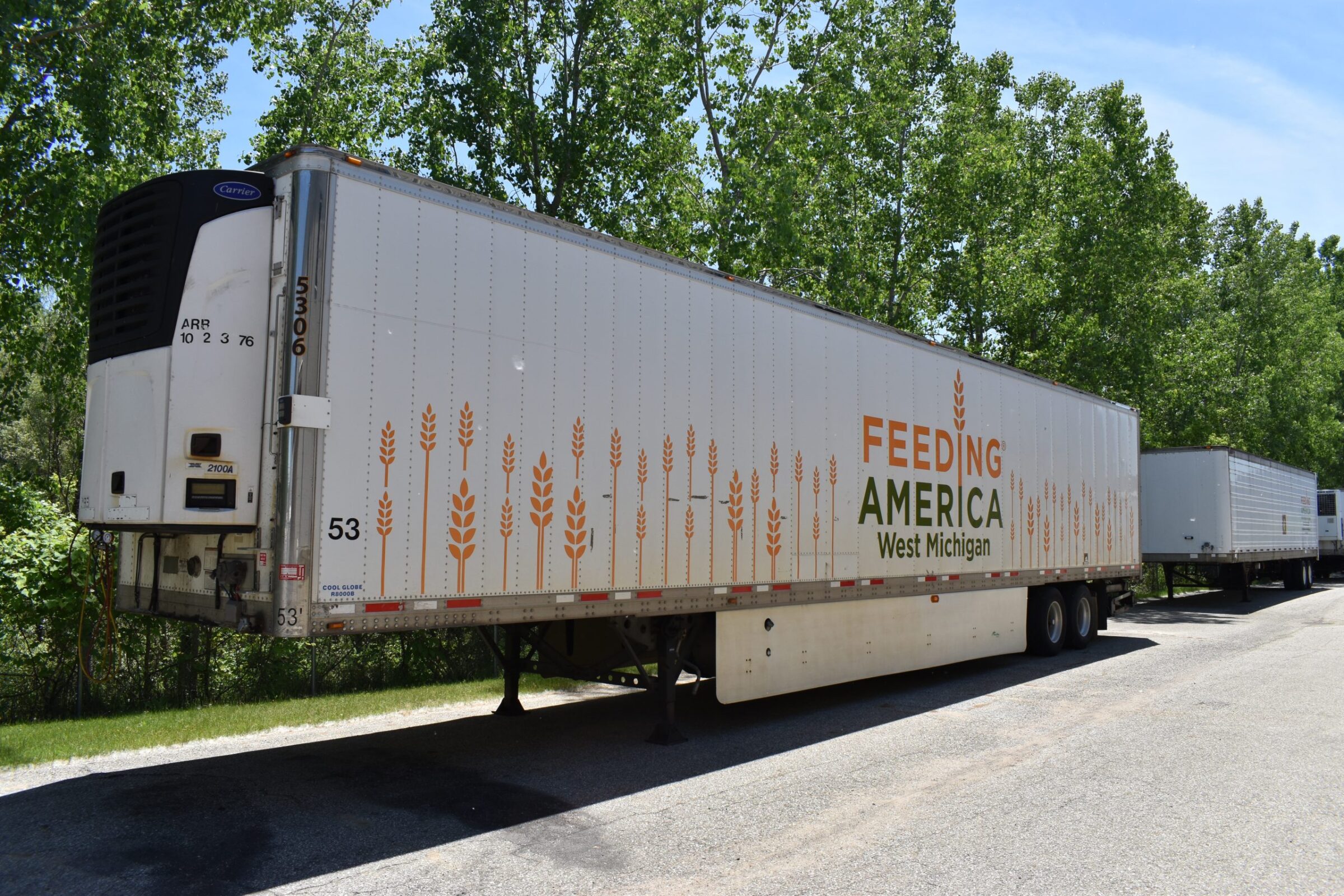 A reefer (back part of a truck) with the food bank's logo on it awaits loading.