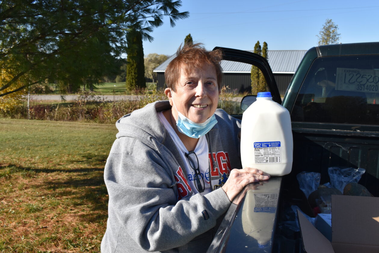 Deborah poses with a gallon of milk.