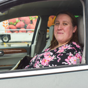 Christine sits in her car as she waits for the Mobile Pantry