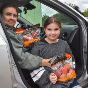 Penny and granddaughter holding fruit