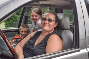 Abuela y nietos sonriendo en auto
