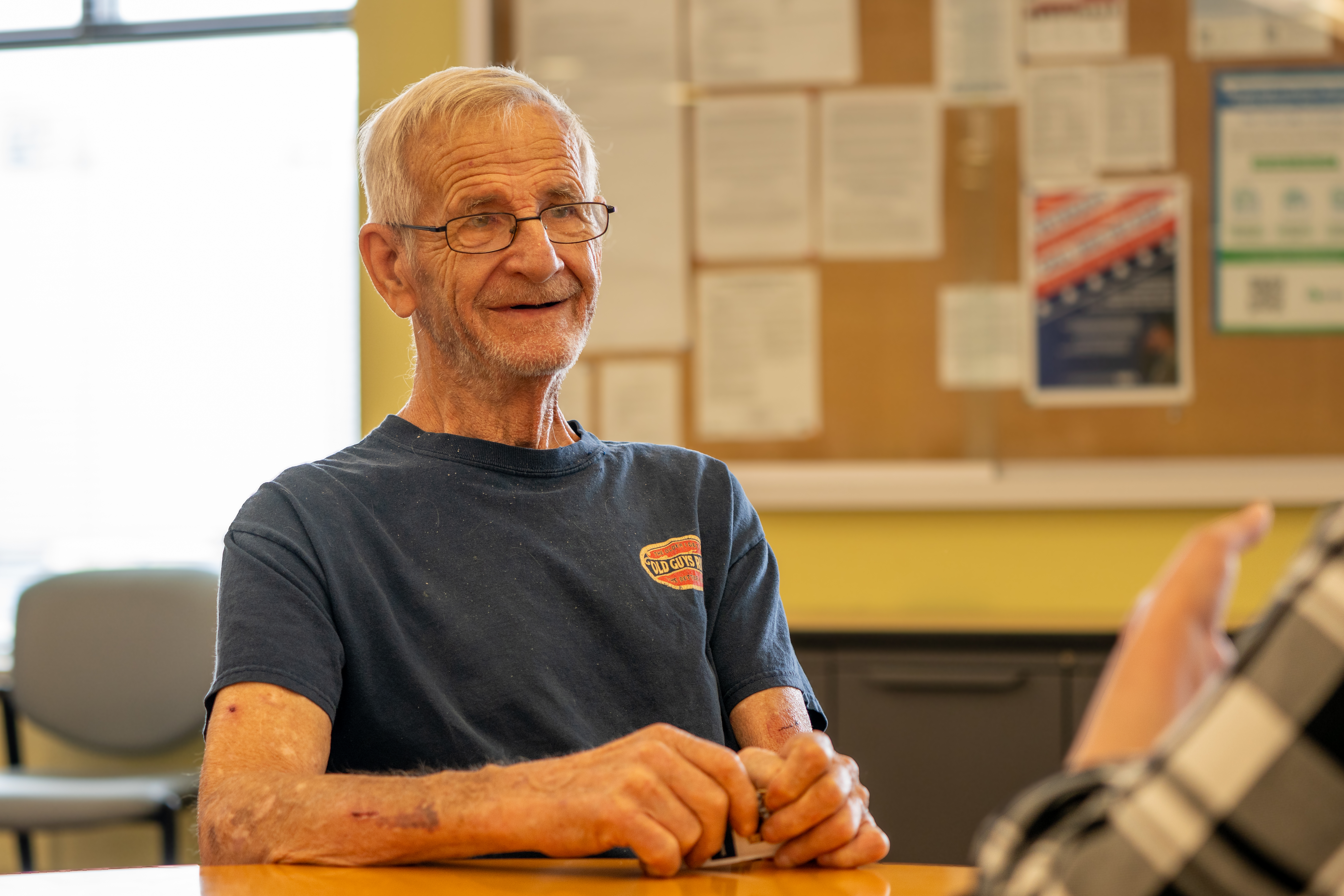 Neighbor John smiling while speaking during an interview.