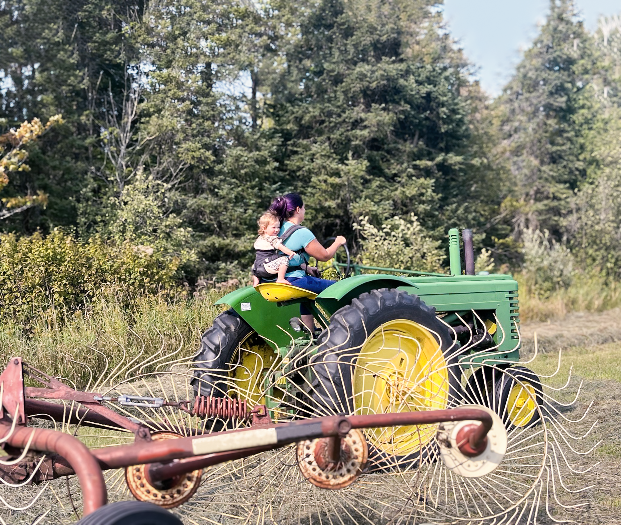 First-generation farmer Maria Case on a tractor with her child.