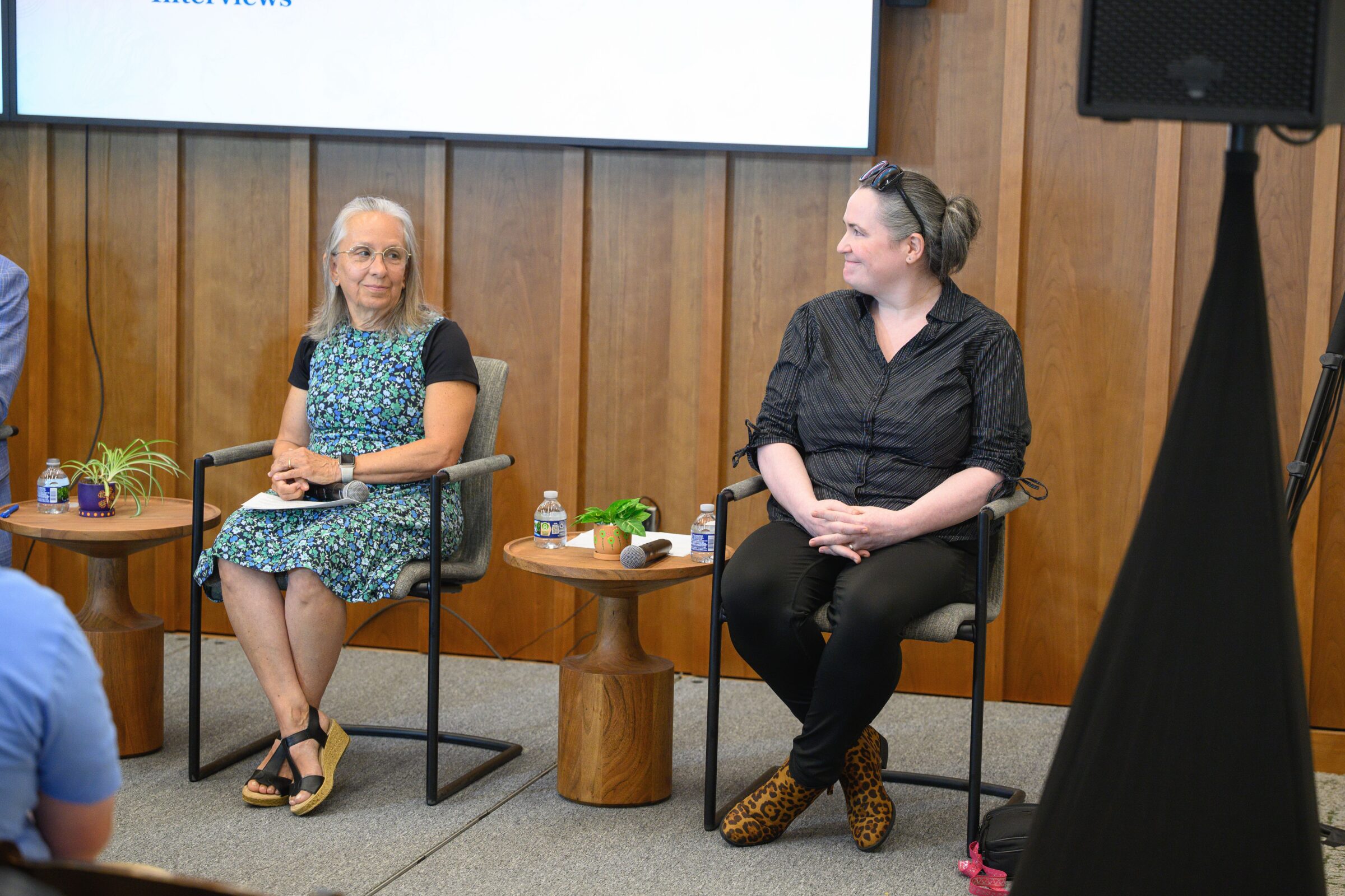 Cheryl and Amanda sitting side-by-side at a town hall panel.