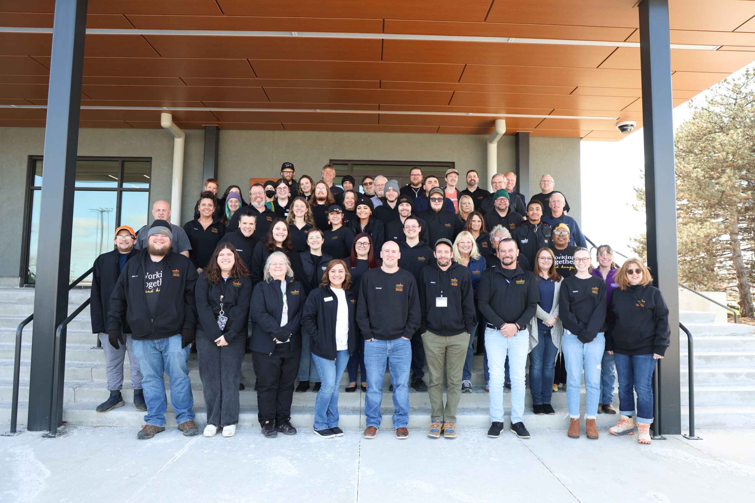 Feeding America West Michigan staff standing on the step to their Kentwood warehouse.
