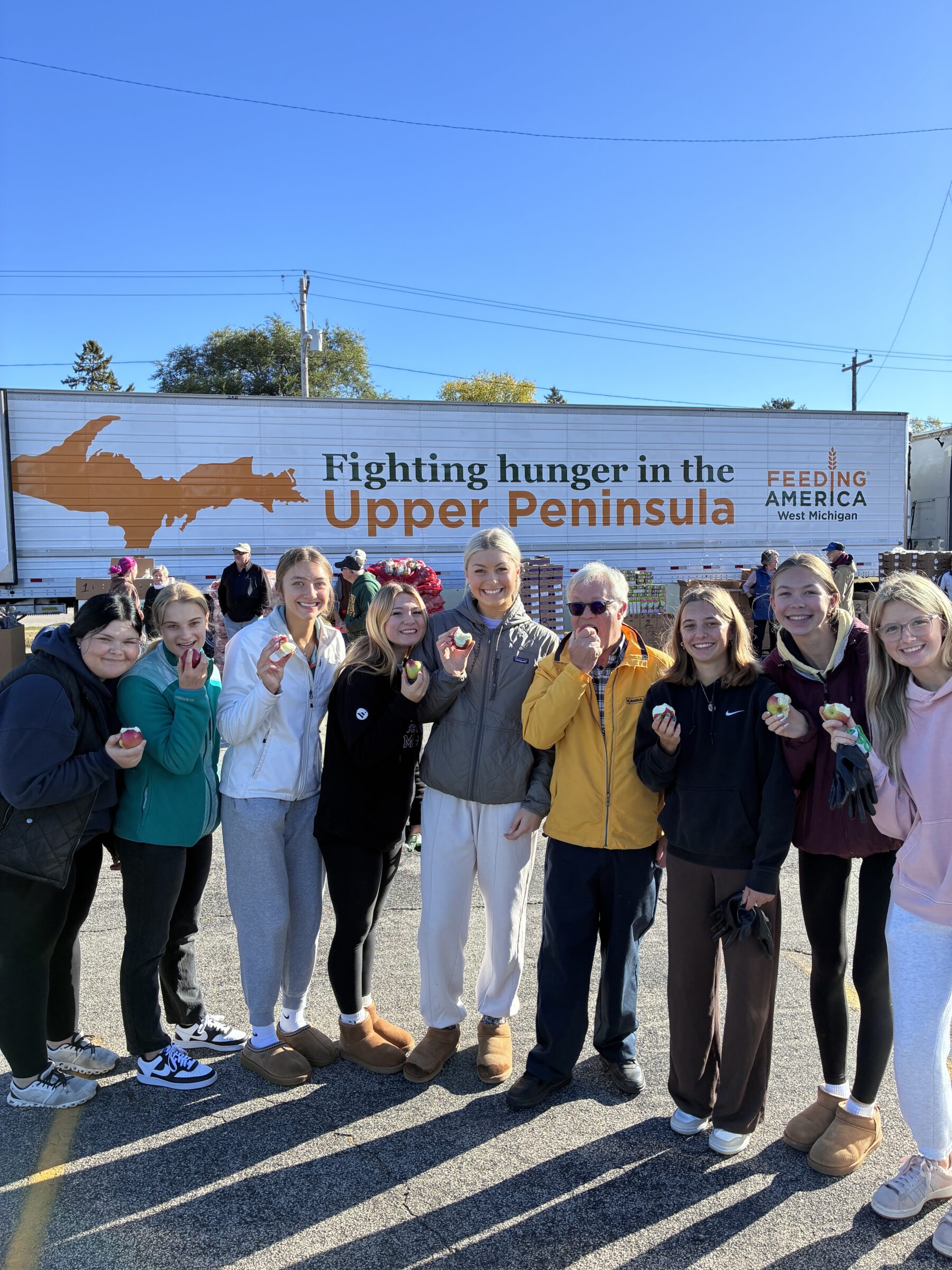 Group of volunteers standing in front of Feeding America West Michigan truck in Menominee County. 