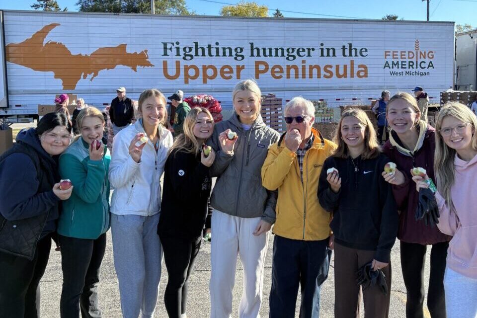 Group of volunteers standing in front of Feeding America West Michigan truck in Menominee County.
