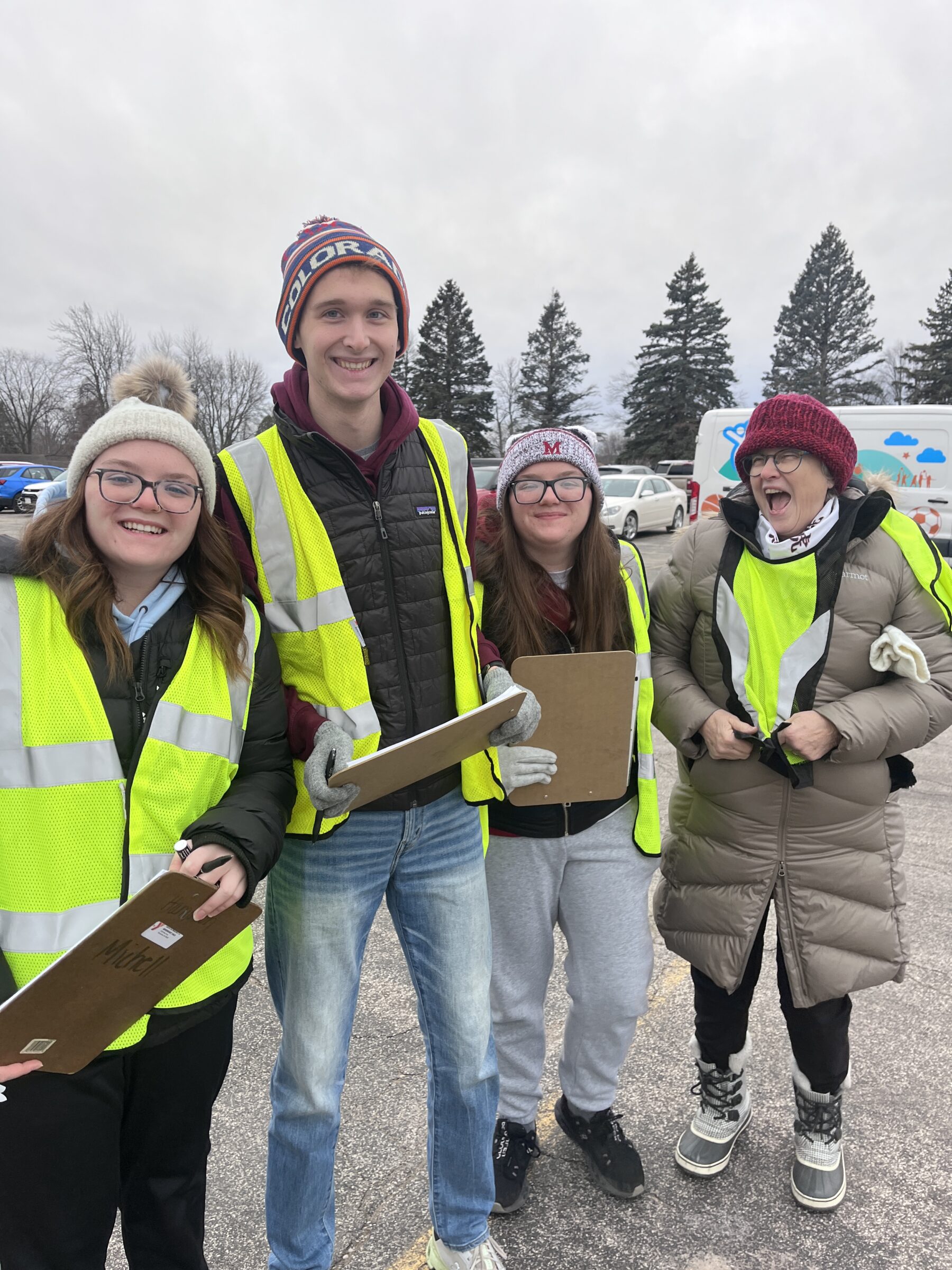 Mobile food pantries volunteers in reflective vests smiling. 
