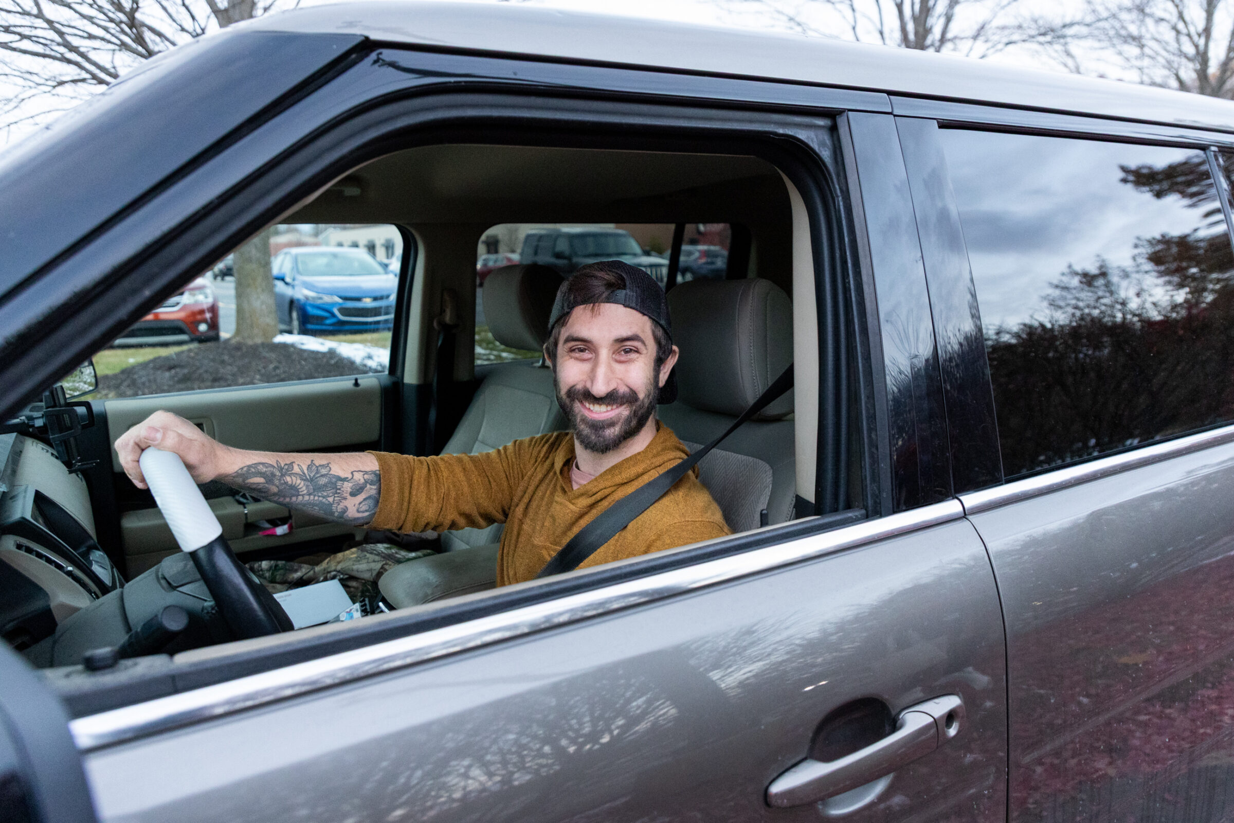 Man smiling in his car. 