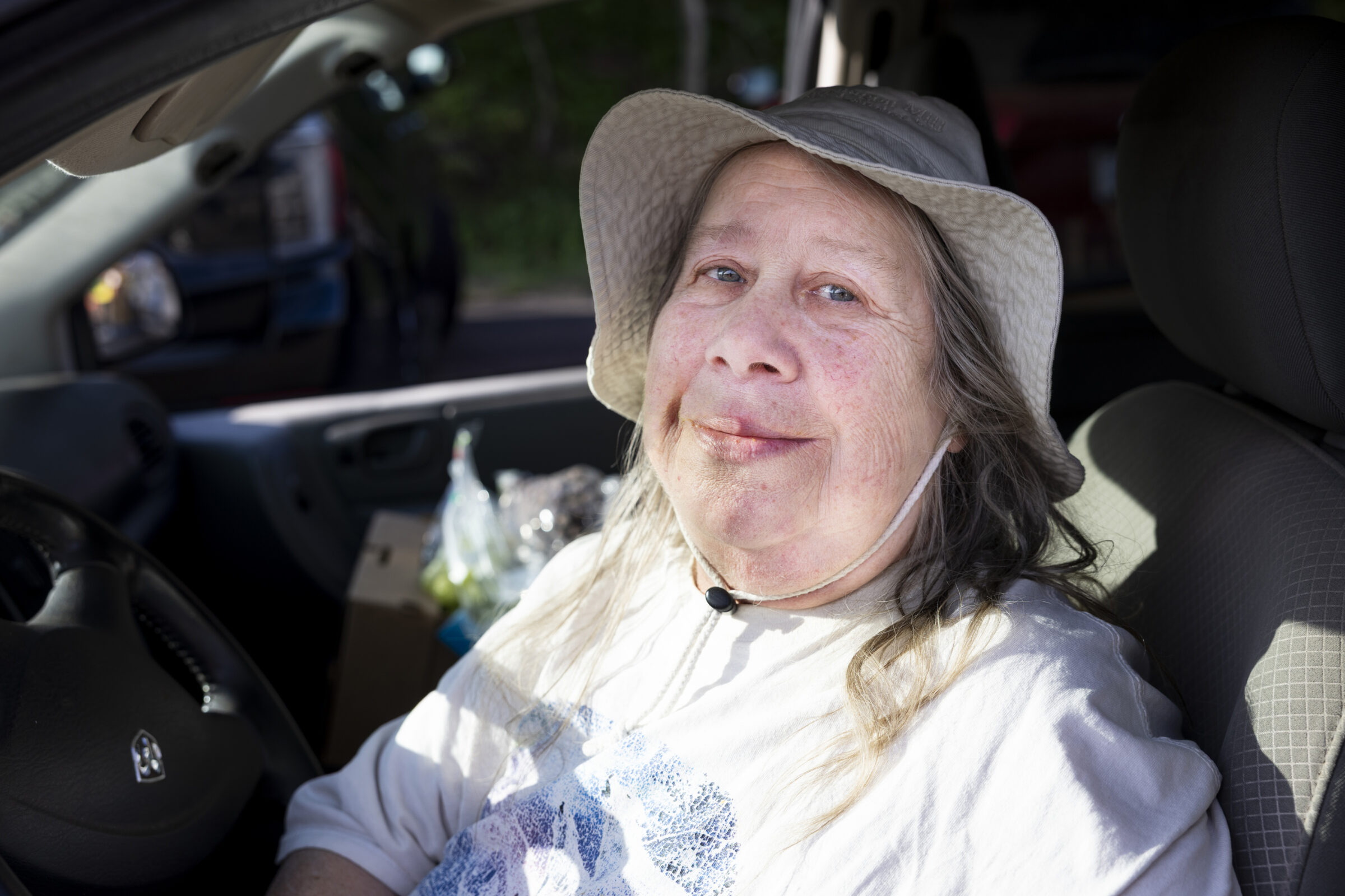 Ishpeming neighbor smiling while she sits in her car.