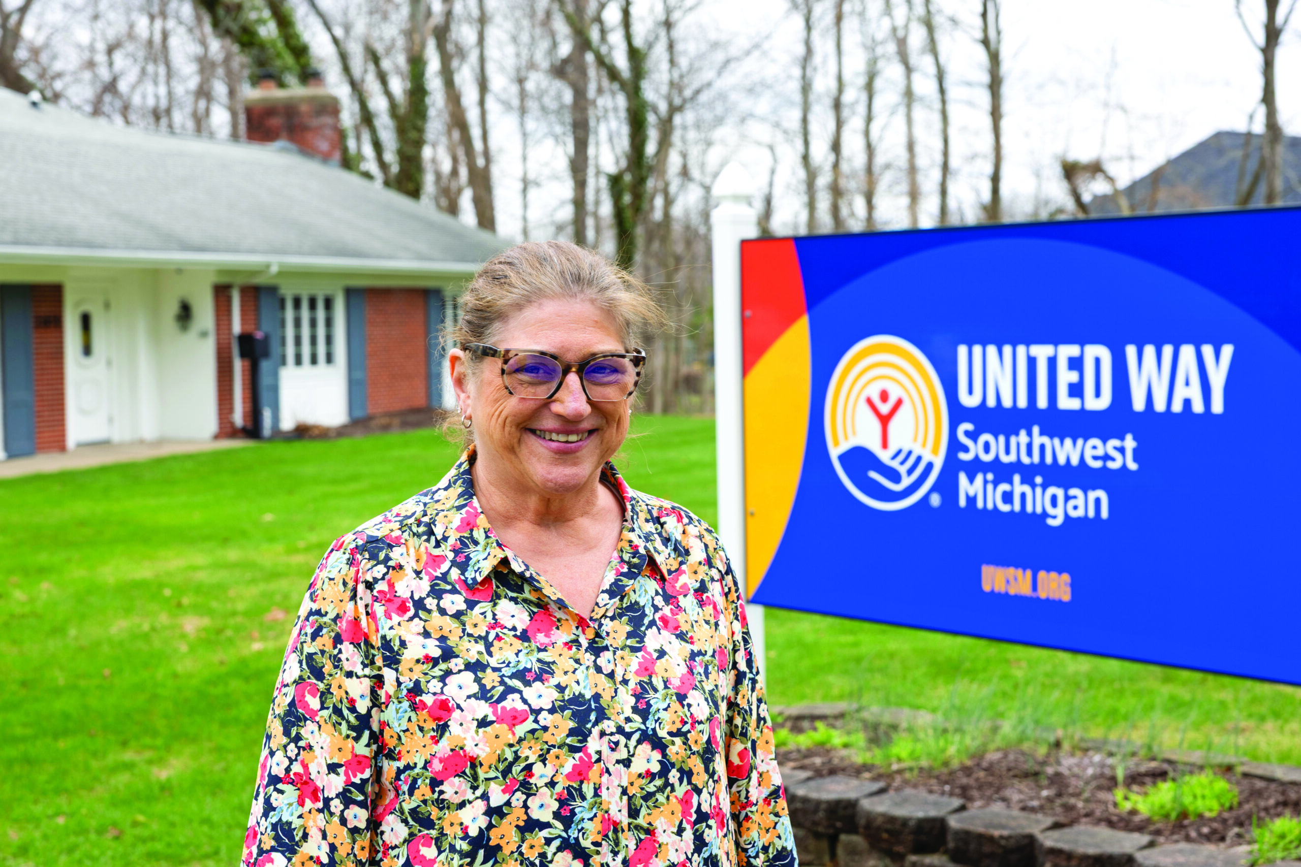 United Way of Southwest Michigan CEO and President, Anna Murphy, smiling while standing next to the United Way's sign.